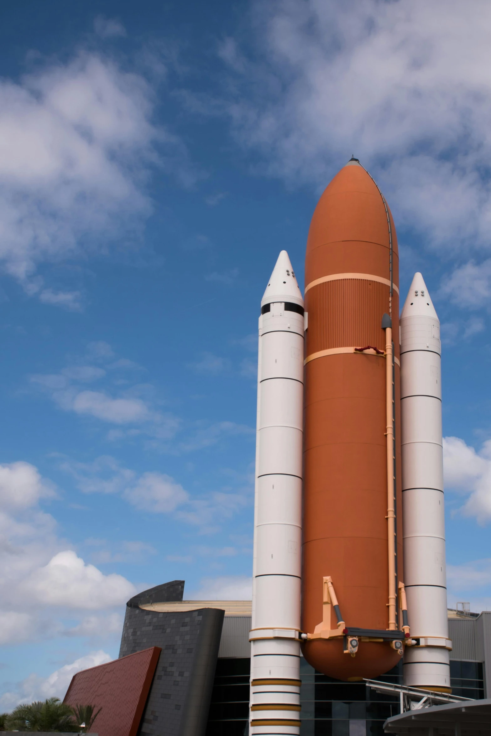 a very large brown and white rocket sitting next to a building