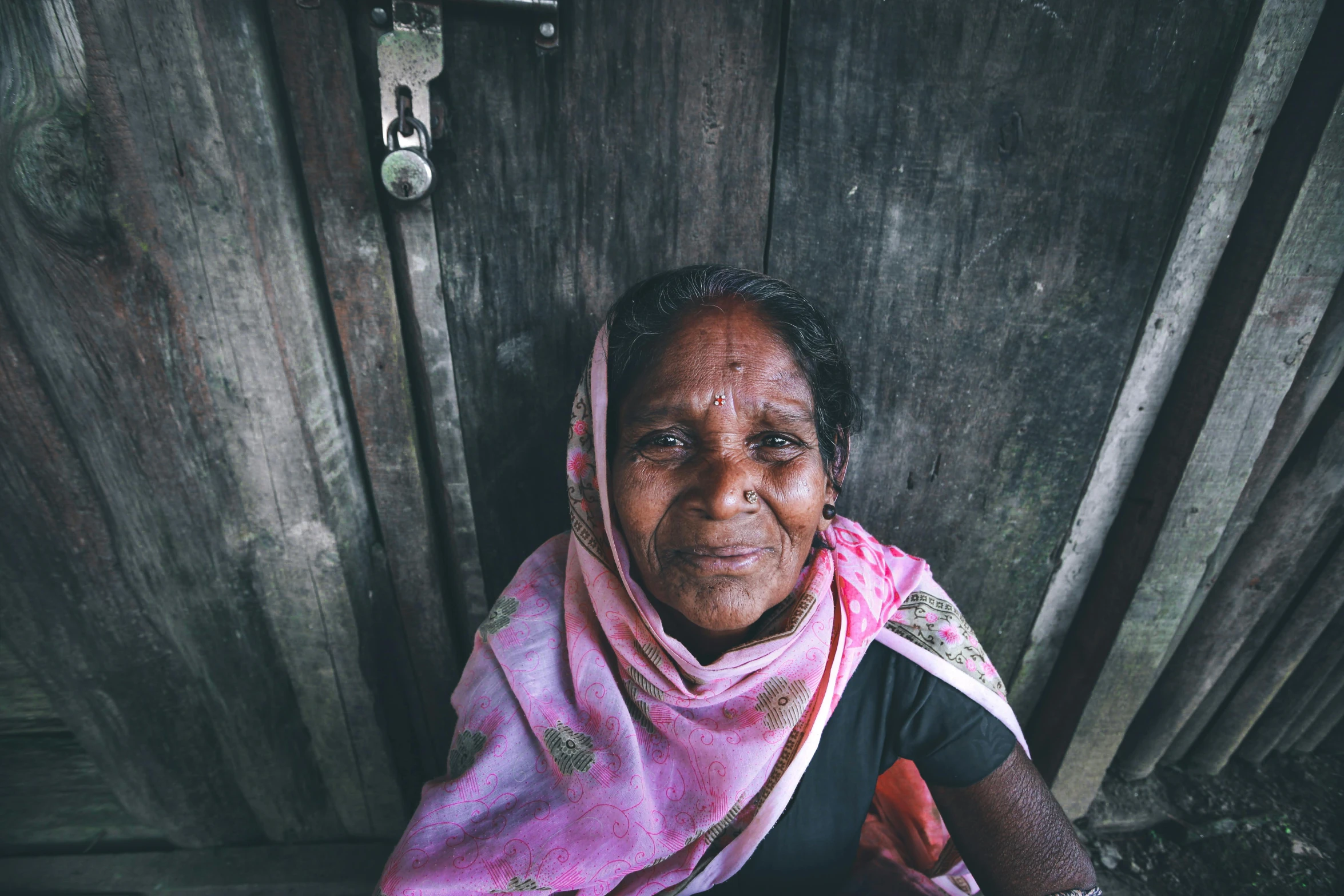 woman with red scarf on in front of wooden doors