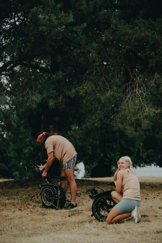 some people are sitting and playing with bikes