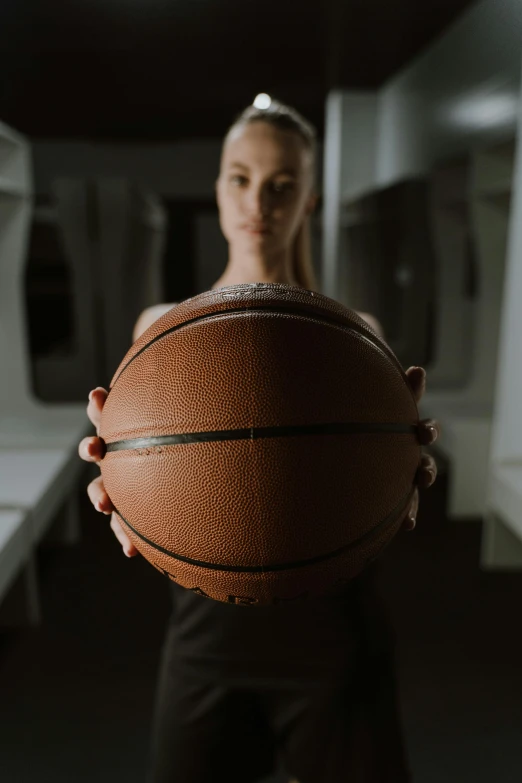 a young woman holding a basketball while posing for a pograph