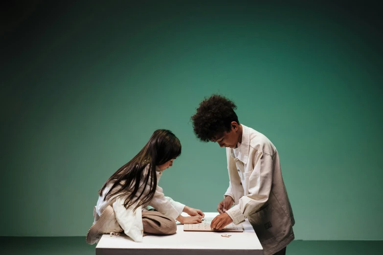 man and woman sitting on counter in front of an object