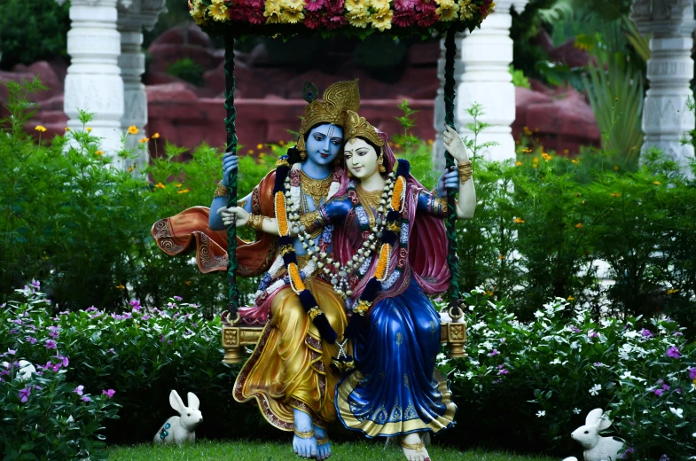 statue of hindu god in garden surrounded by flowers