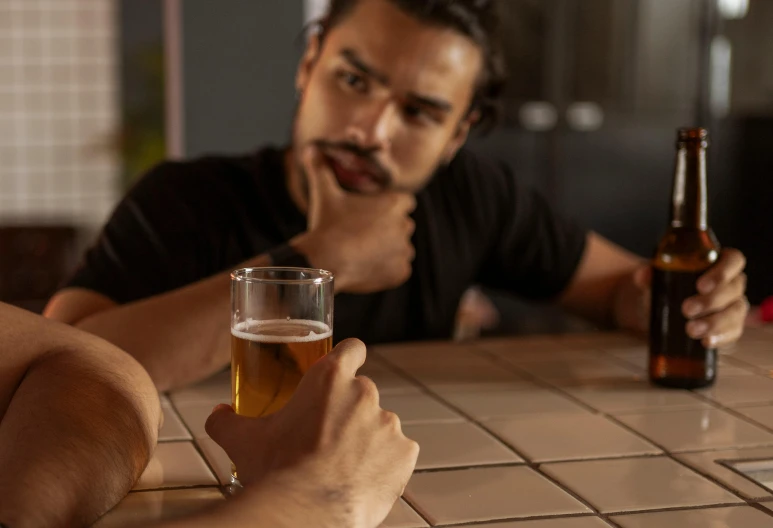 a man wearing glasses is holding a beer