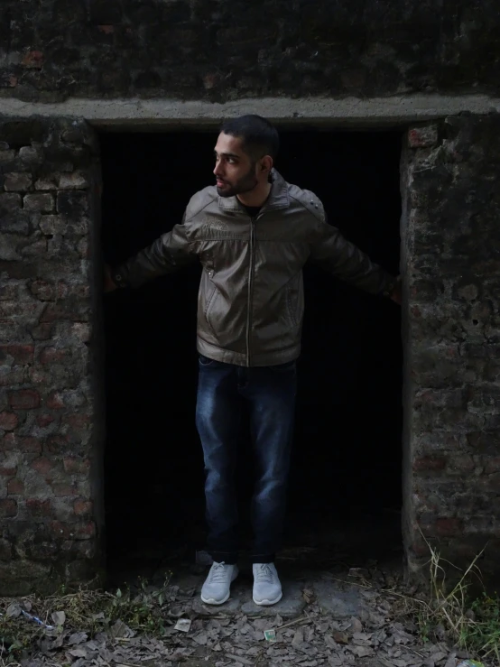 a young man is standing in the entrance to an old brick building