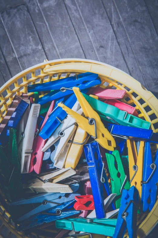 assorted pairs of scissors in yellow basket with wooden board