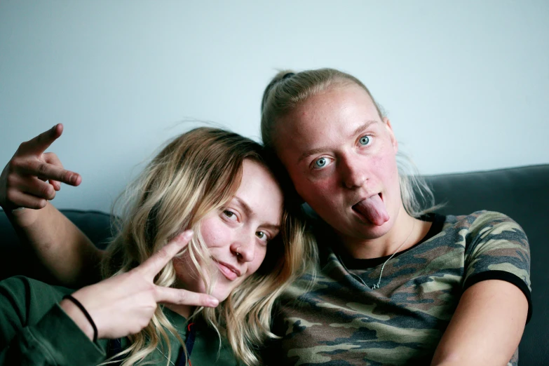 two women sitting on a couch and making faces