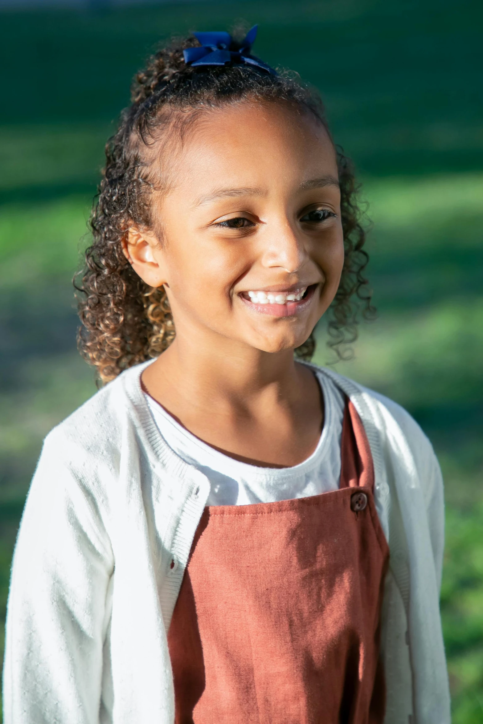 a child smiling and wearing an apron