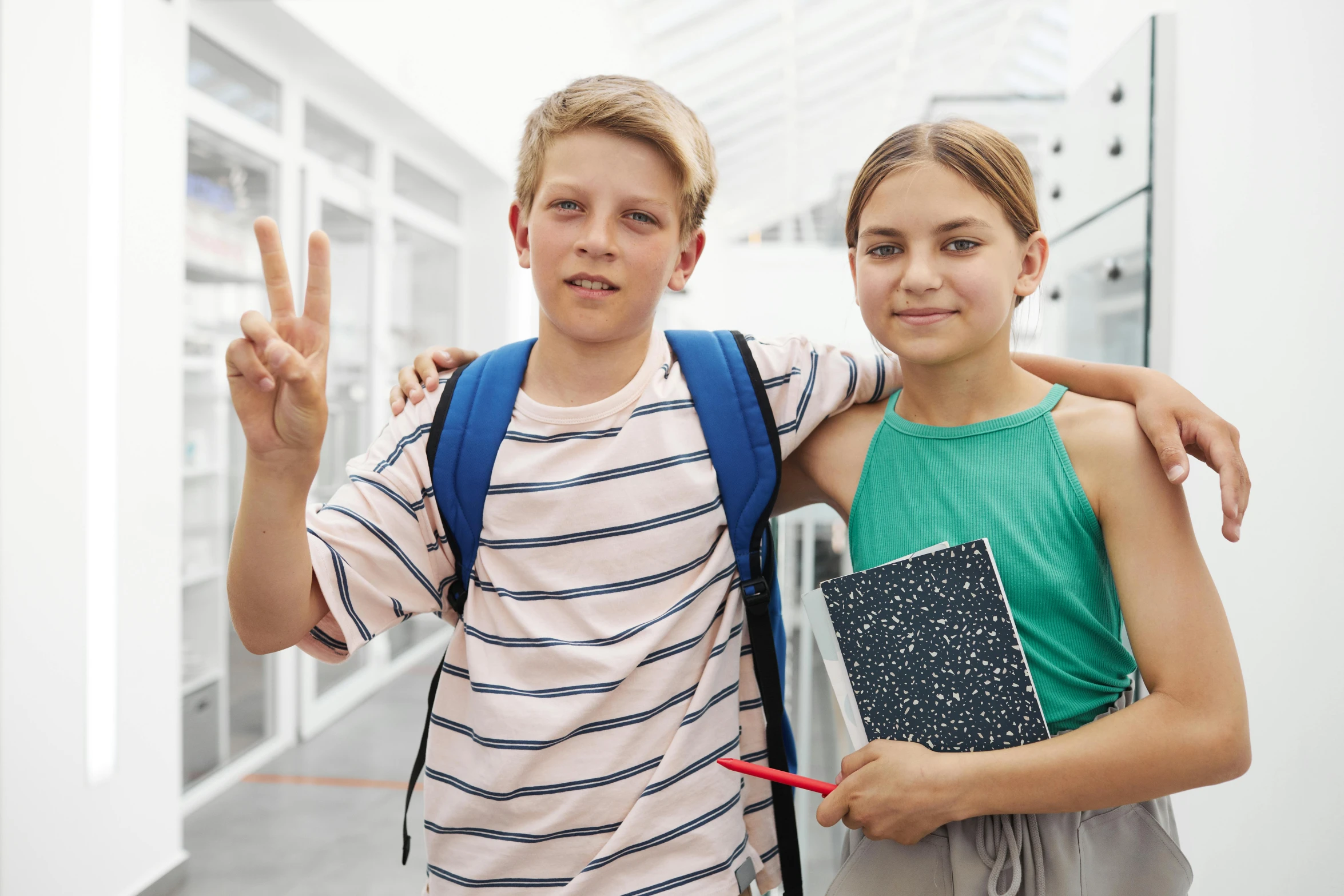 two children are smiling and showing victory signs