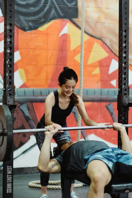 a man and woman doing squat lifts for barbells