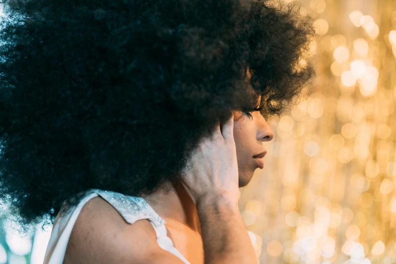 an afro woman with big black hair using her phone