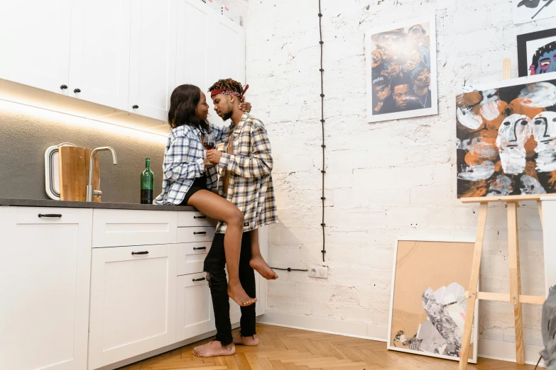 two people hugging in the middle of a kitchen