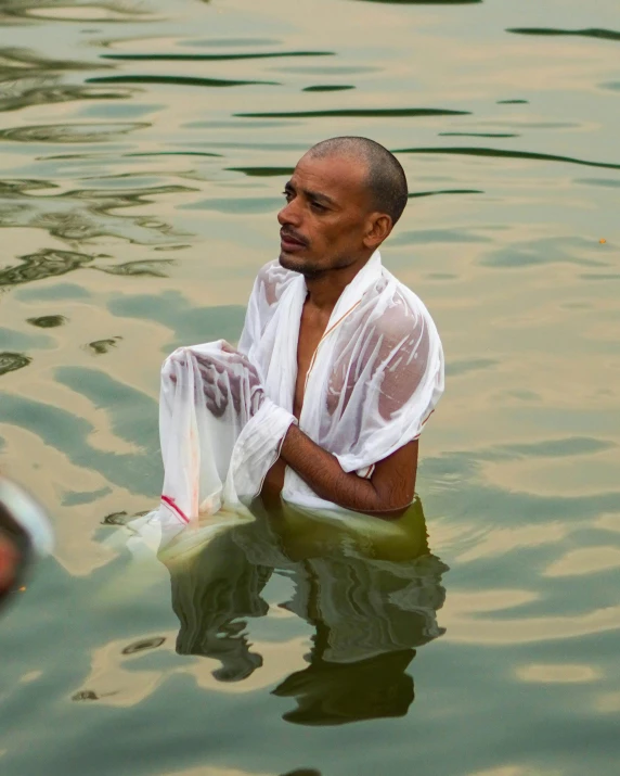 a man is sitting in the water alone