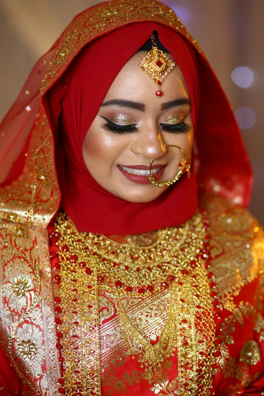 a woman with a gold head piece and red headscarf