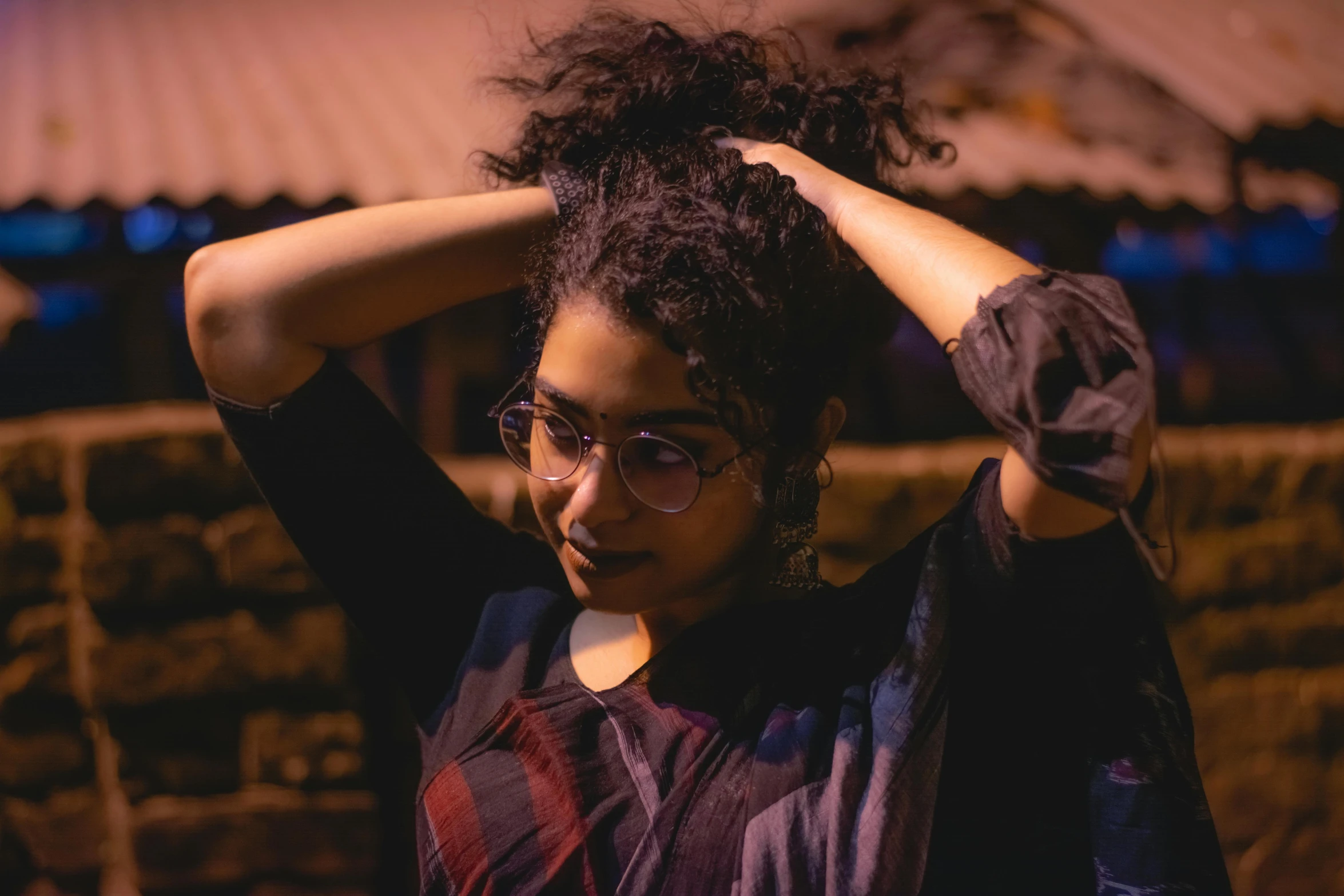 a young woman is wearing glasses and holding her hair