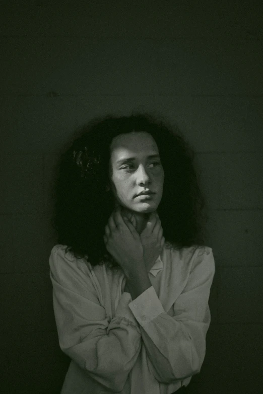 a woman with her arms crossed poses against a black background