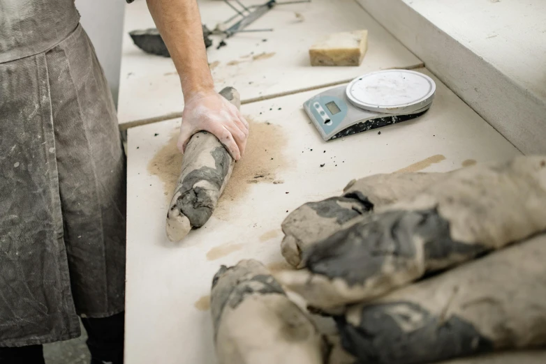 a person in a kitchen using a machine to sand up some fabric