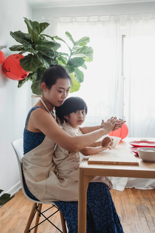 two women are sitting at a table preparing to cook food