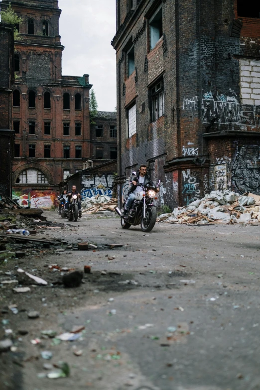 two motorcycles parked on a dirty street next to buildings