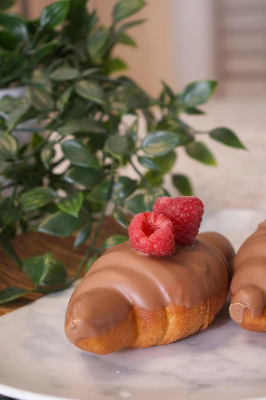 two pieces of pastries on a plate with raspberries