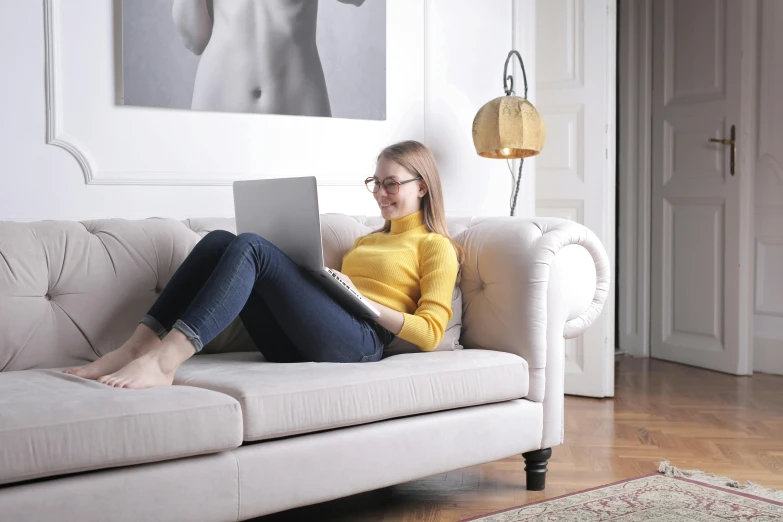 a woman sitting on a couch with a laptop