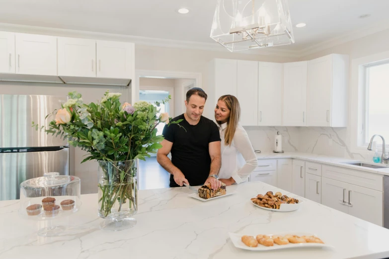 two people preparing food inside of a large kitchen