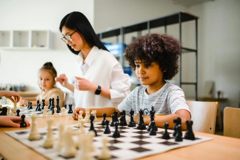 three women playing chess with a child