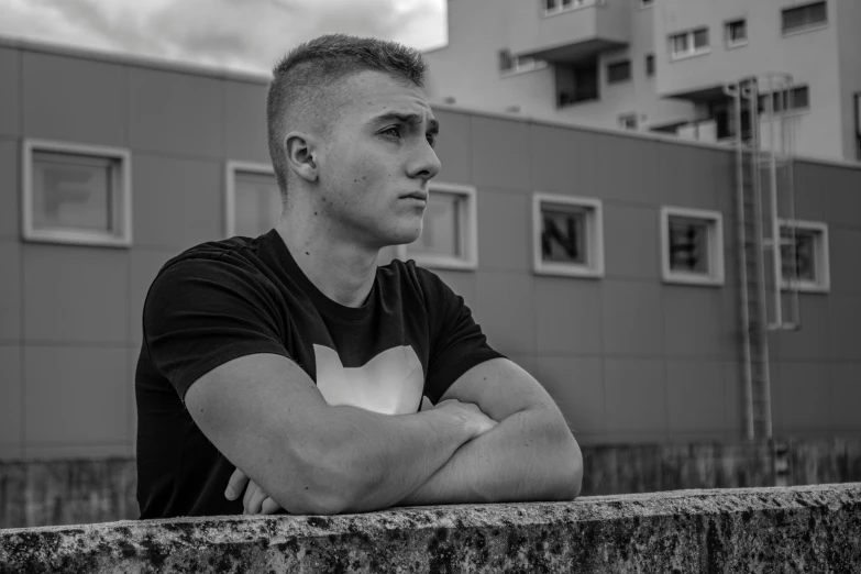 a young man standing with his arms crossed in front of him