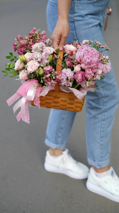 a person is holding a basket with flowers