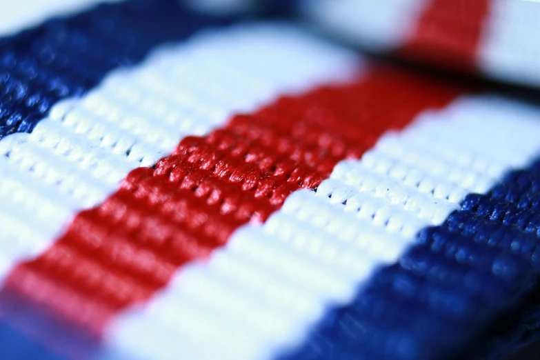 a close up view of a cross stitch red white and blue