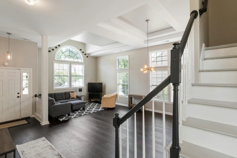 a room with white walls, windows and wood floors