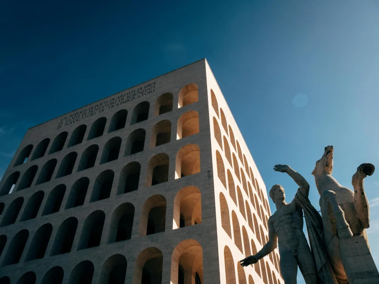 a very tall white building with some statues