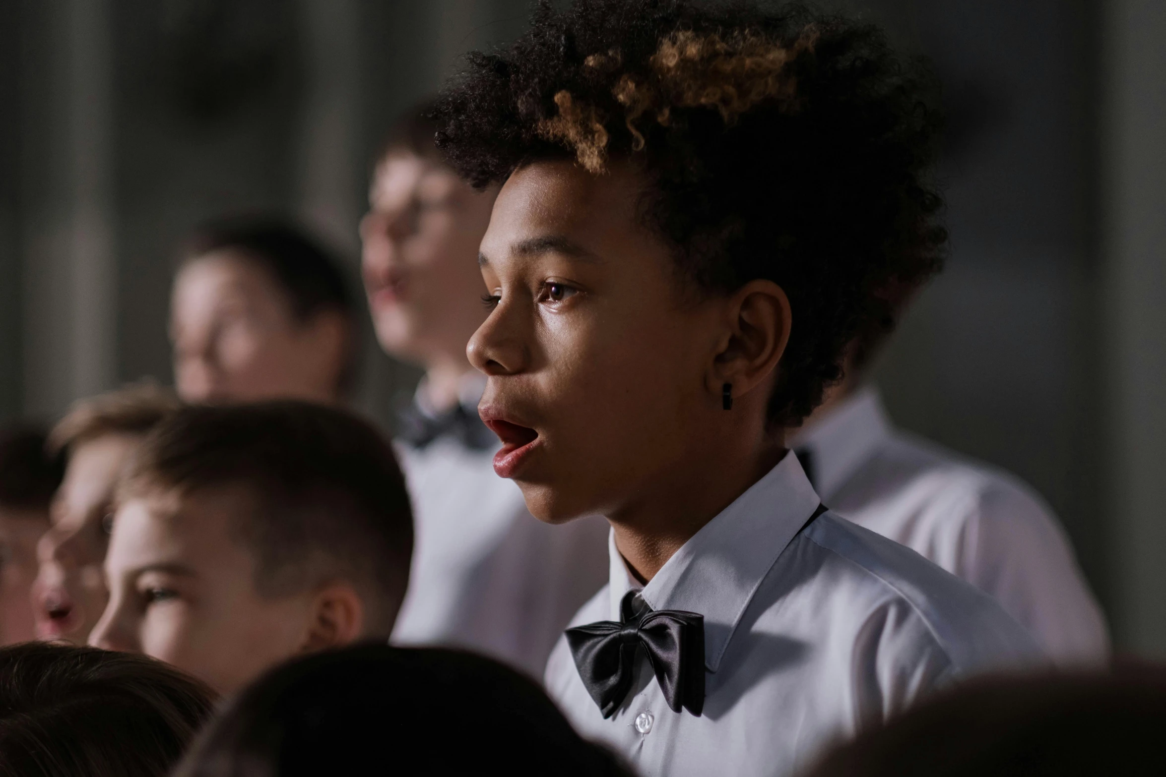 several young children with black hair and bow ties