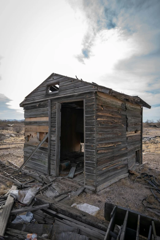 a dilapidated old shack with weathered windows in an empty field