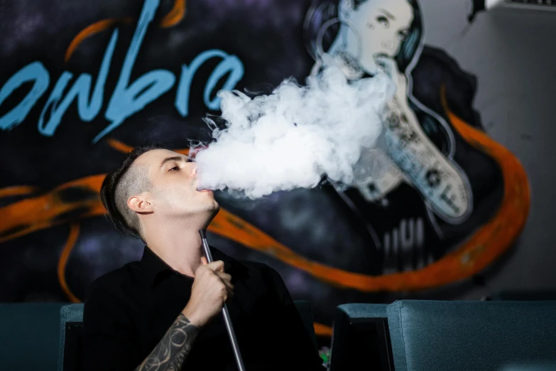 a man that is blowing smoke into the air