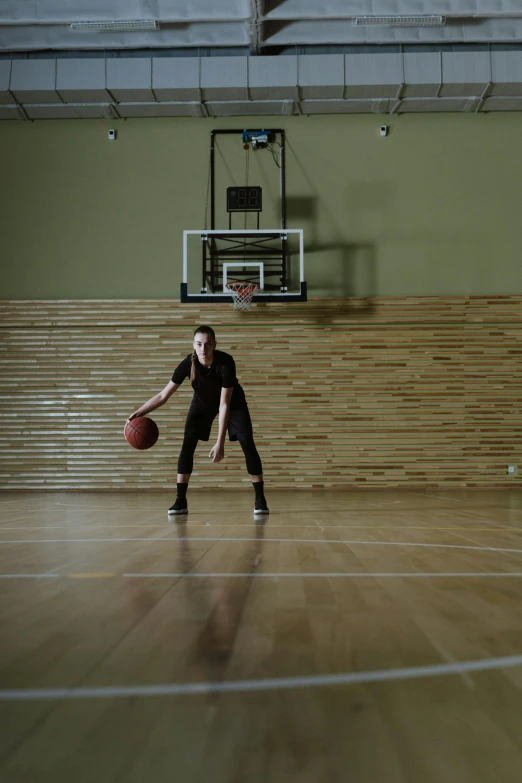 a basketball player standing in a gym ready for his turn to serve