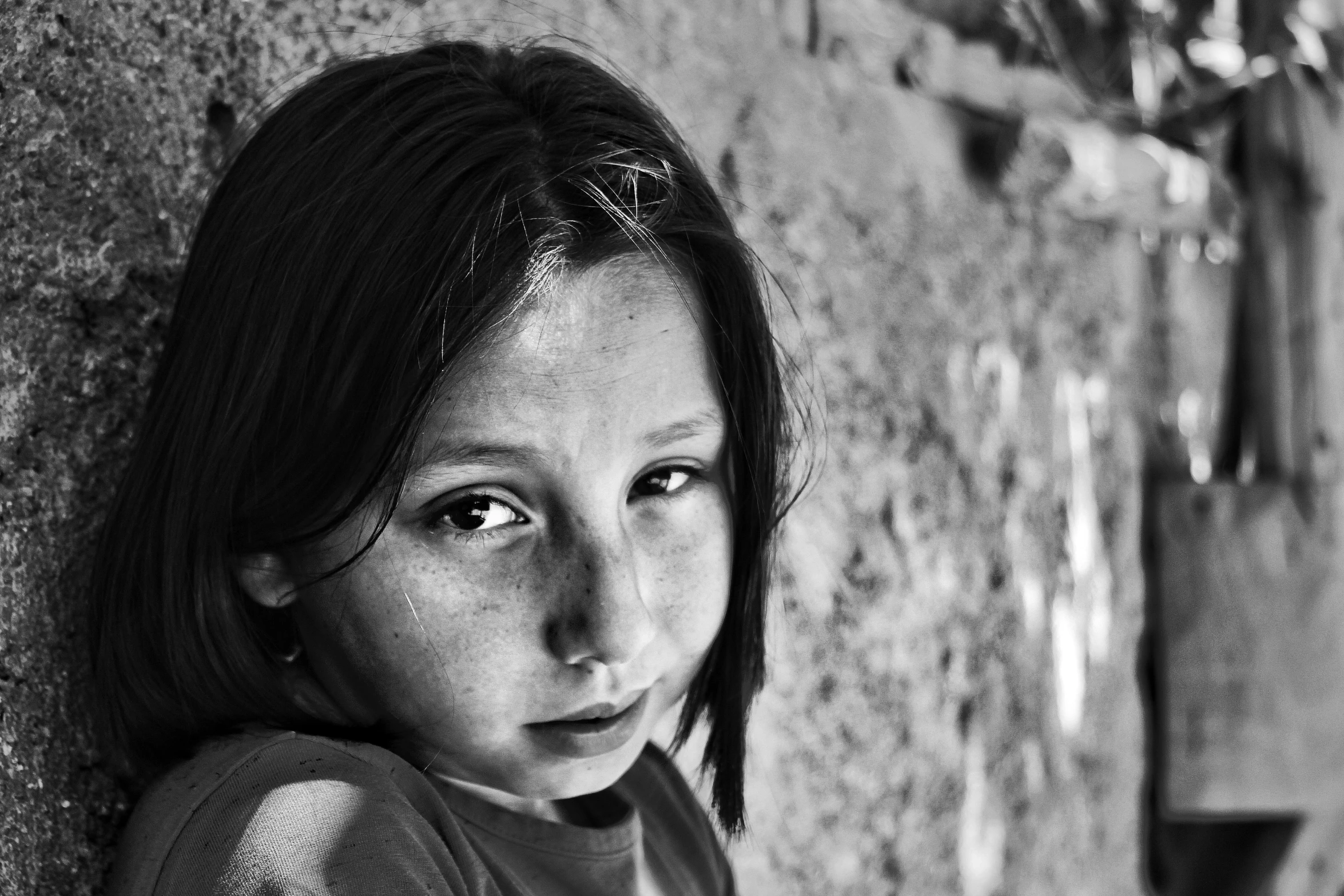 the young child is standing in front of a wall