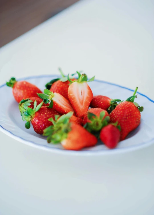 a bunch of strawberries are on a white plate