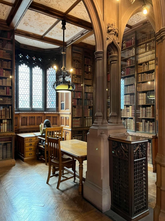 a room with many bookshelves and tables on the floor