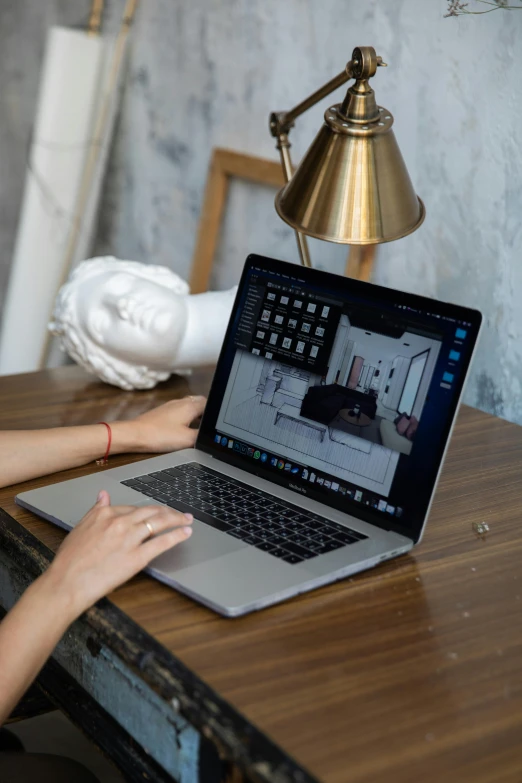 a woman at her computer with a lamp beside her