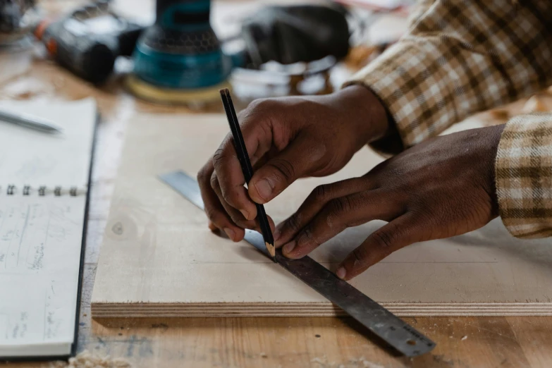 an engineer writing soing on a piece of wood