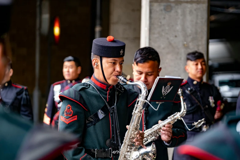 the men in the military uniform are playing instruments