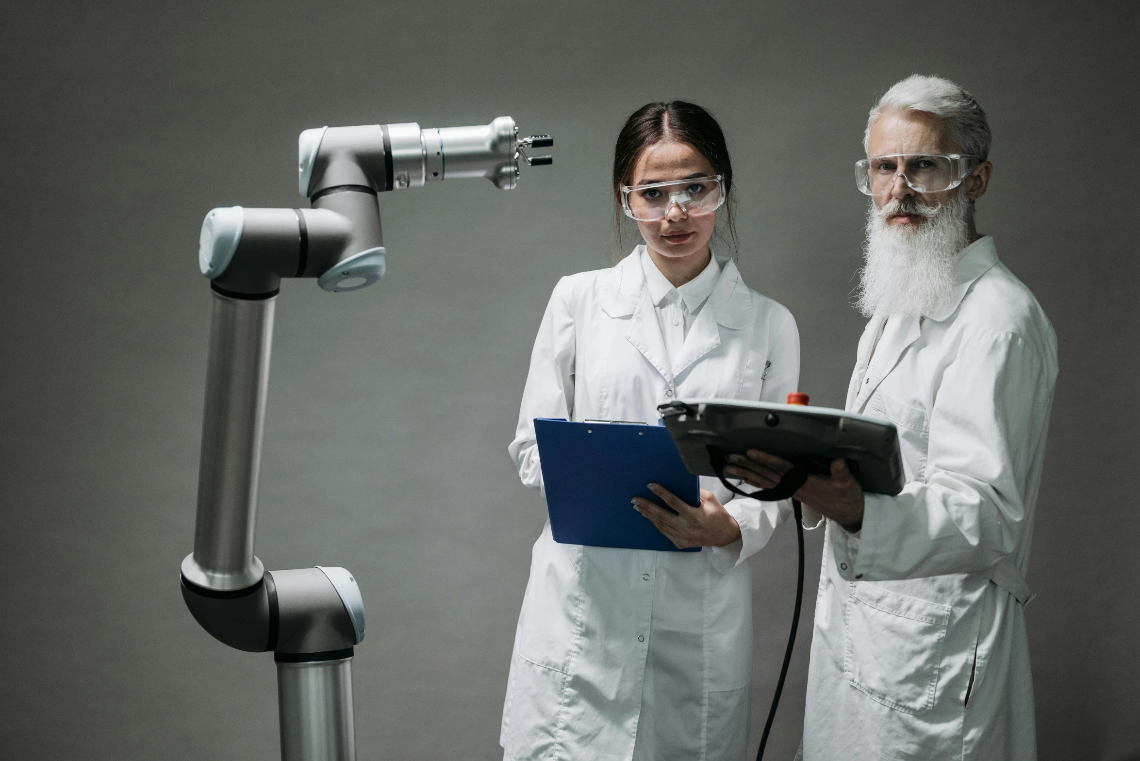 two people stand in front of microscope equipment