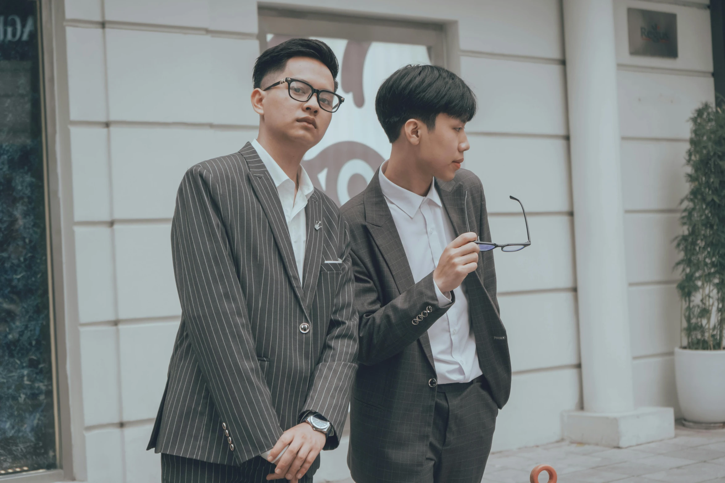 two asian men walking in front of a building