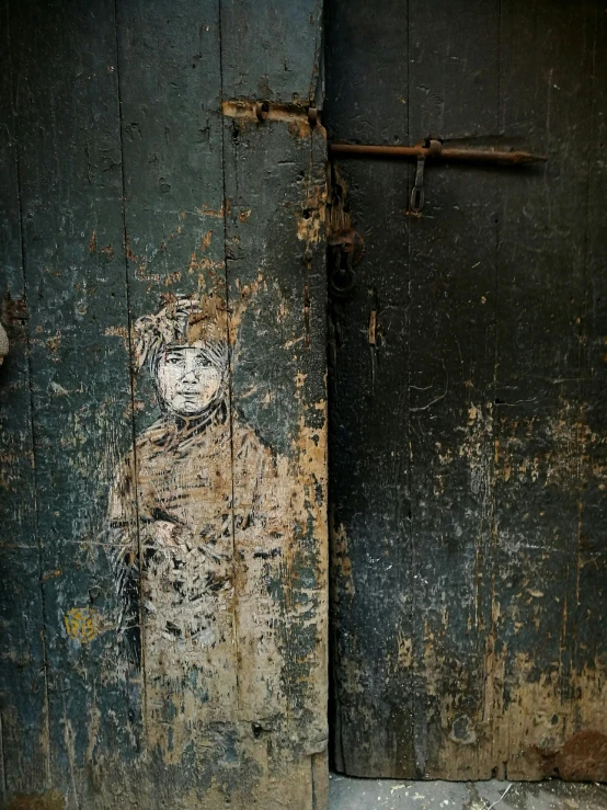 an old dirty bathroom door with paint peeling off