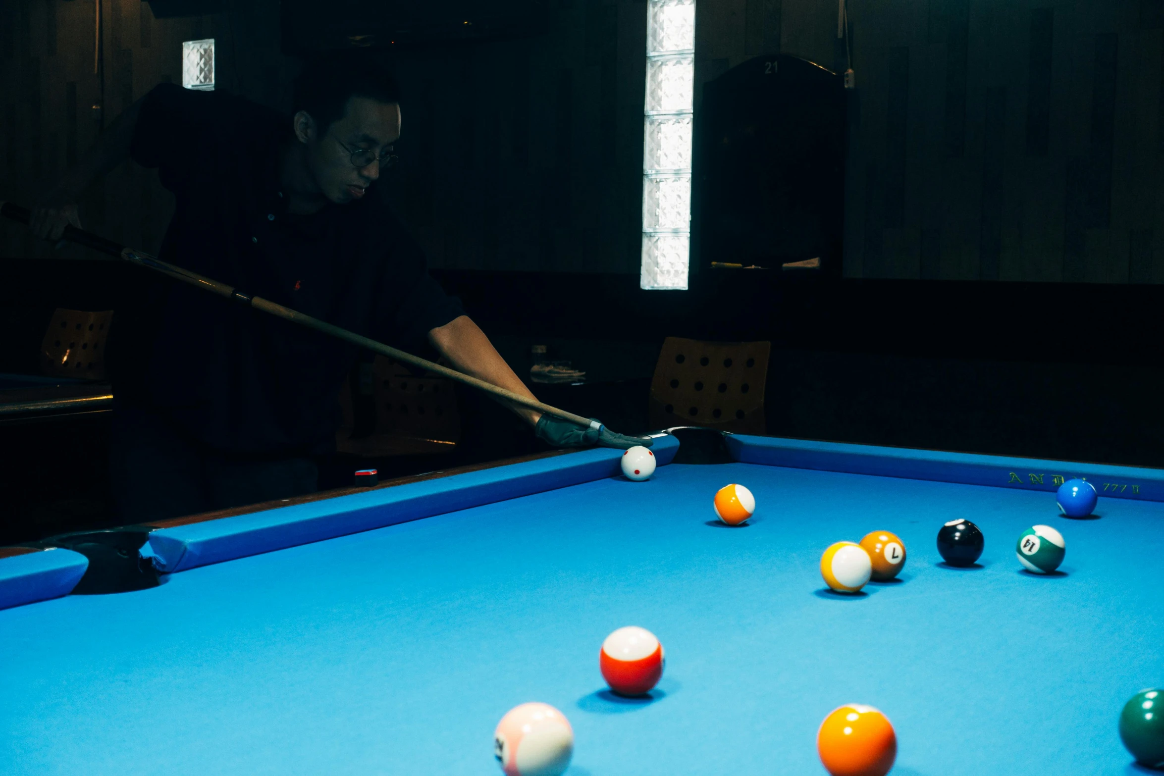 a man with a cue in his hand is playing pool