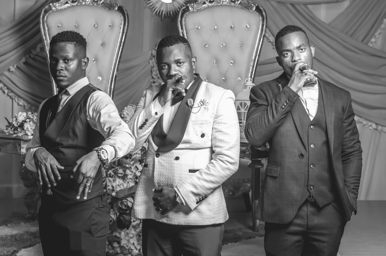 three black men are in their suits posing together