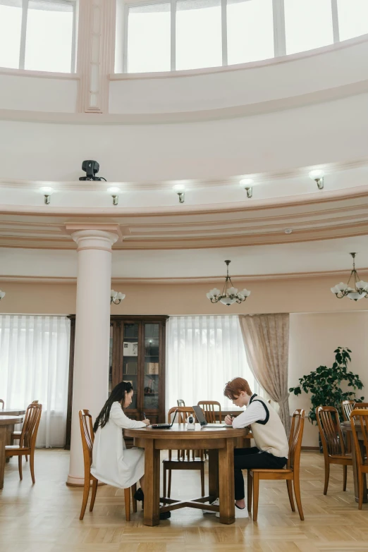 two people sit at a table with food