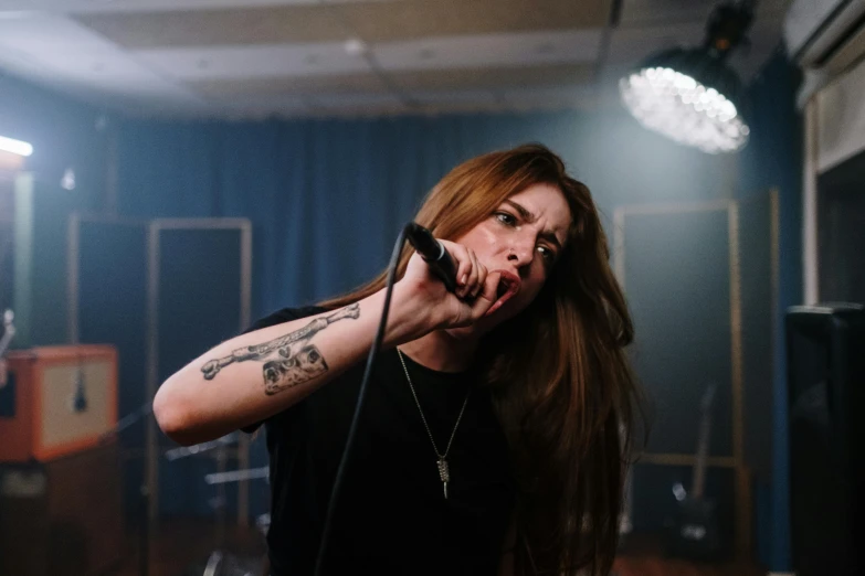 a young lady on stage holding a microphone to her ear