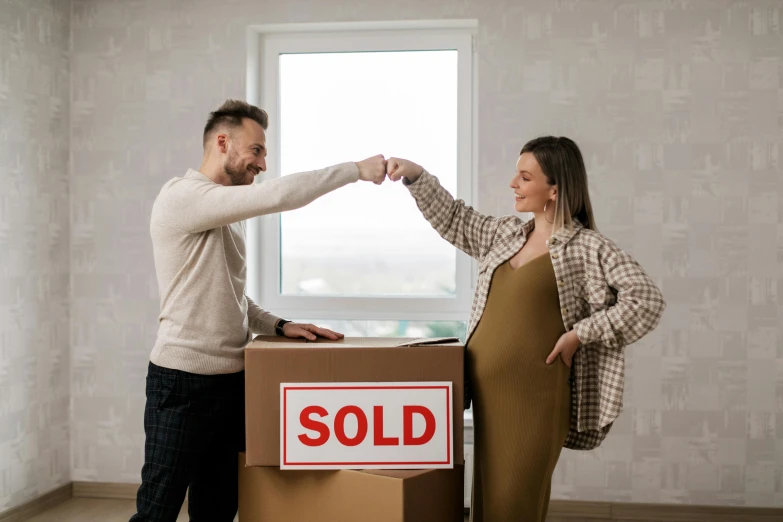 a man and woman standing next to a box holding keys