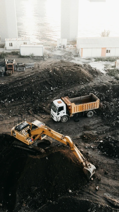 dump truck is near the construction site with the machinery nearby